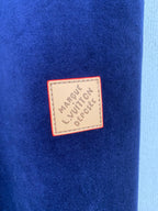 Close-up of dark blue fabric with a Louis Vuitton logo patch