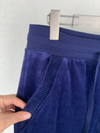 Dark blue sweatpants with ribbed cuff and drawstring, held by hand