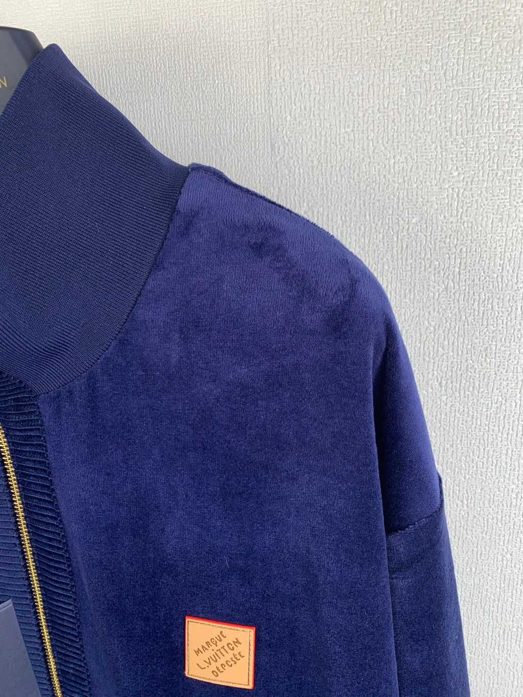 Blue Louis Vuitton jacket sleeve with small leather logo patch near hem