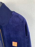 Blue Louis Vuitton jacket sleeve with small leather logo patch near hem