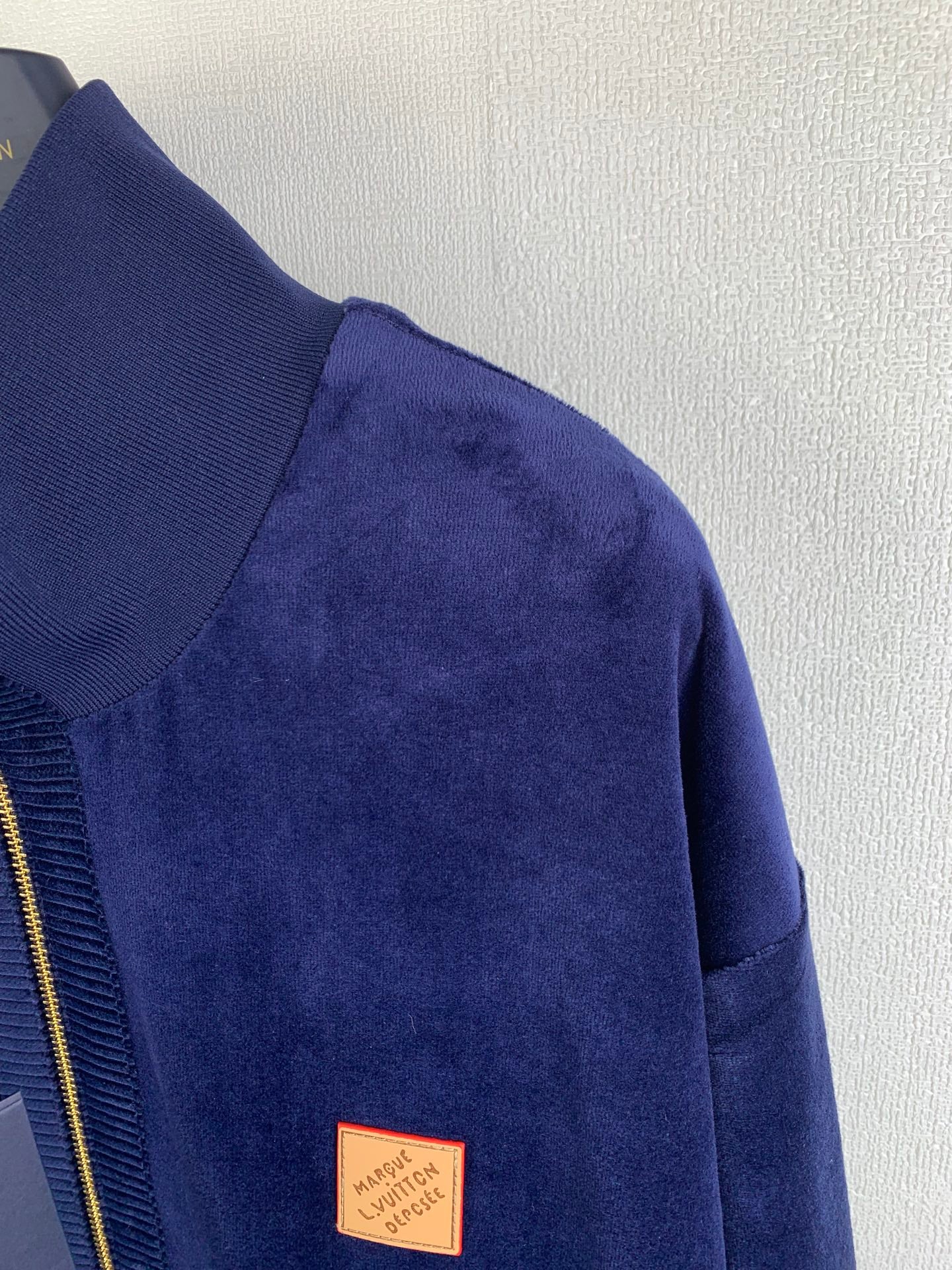 Blue Louis Vuitton jacket sleeve with small leather logo patch near hem