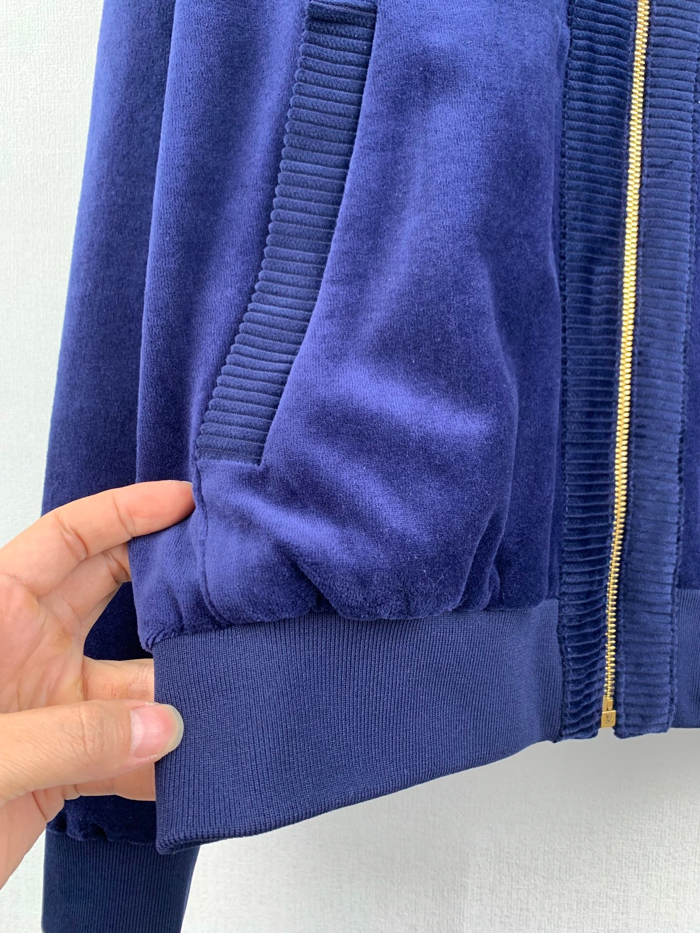 Blue Louis Vuitton jacket front pocket area with ribbed trim and zipper edge