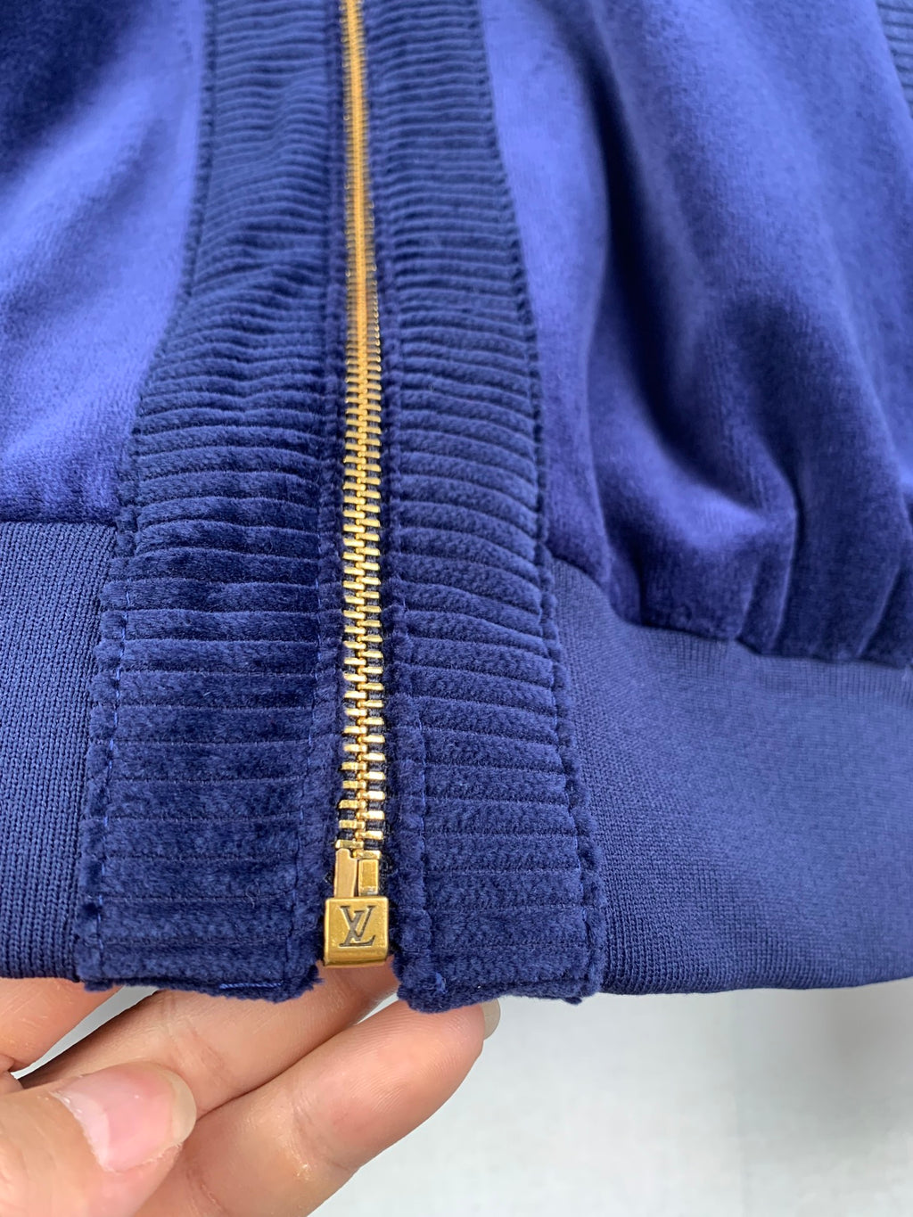 Blue Louis Vuitton jacket zipper with gold pull and textured ribbed panel