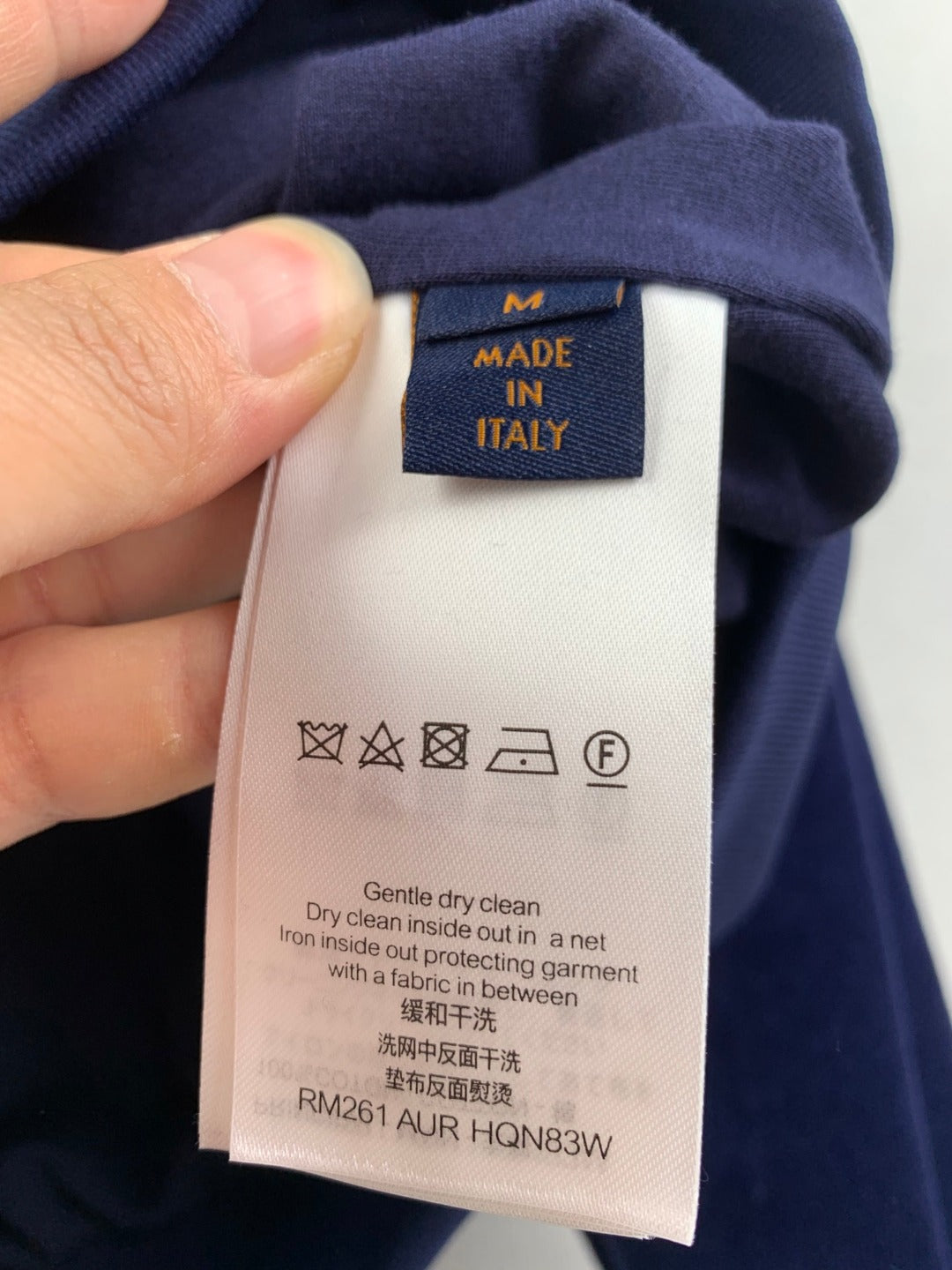 Louis Vuitton long clothes care tag on dark blue long-sleeve garment
