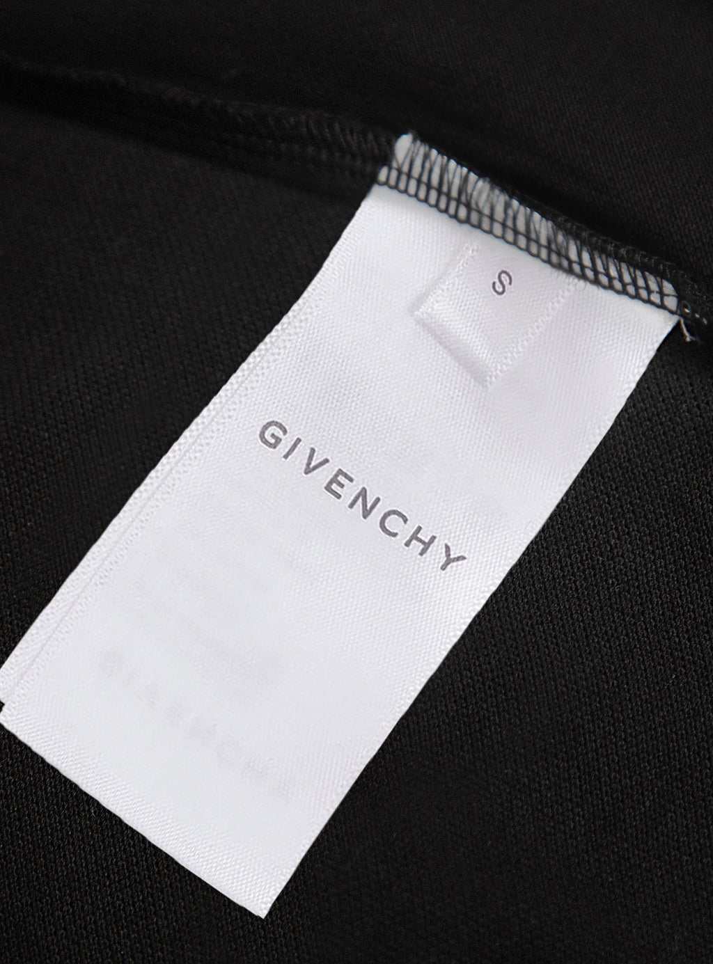 White size label marked S on black polo shirt