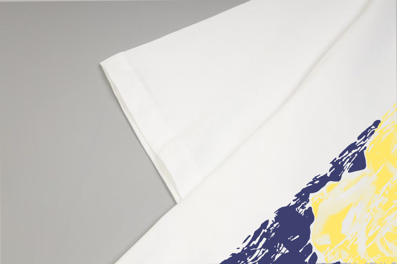 White T-shirt sleeve and side section with navy and yellow abstract print