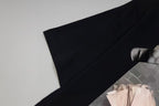 Black T-shirt laid flat with sleeve and partial chest print