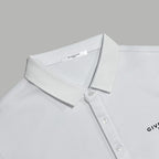 White polo shirt close-up with collar, button placket, and chest logo