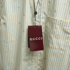 Light blue striped shirt with GG pattern and hanging Gucci tag