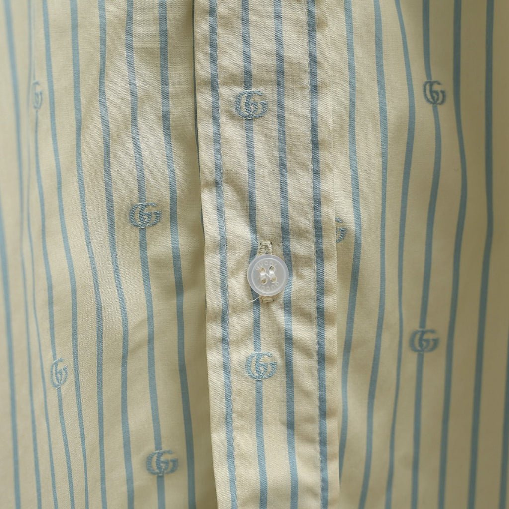 Light blue striped shirt fabric with small GG logos and round button