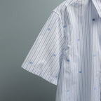 Short-sleeve button-up shirt side view with blue-striped pattern and buttons