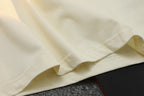 Cream T-shirt sleeve and hem seam detail