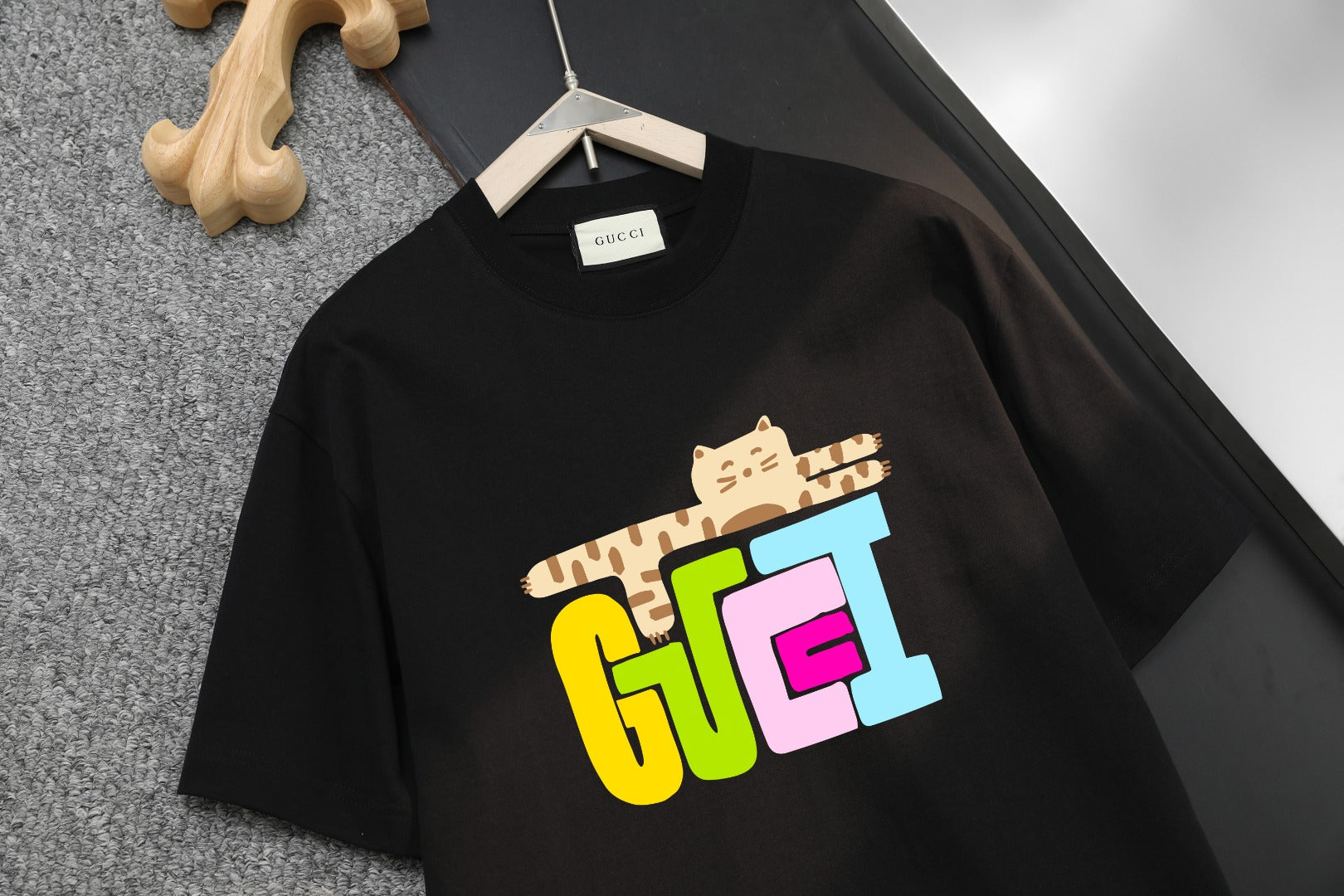 Black T-shirt front with large multicolor cat graphic