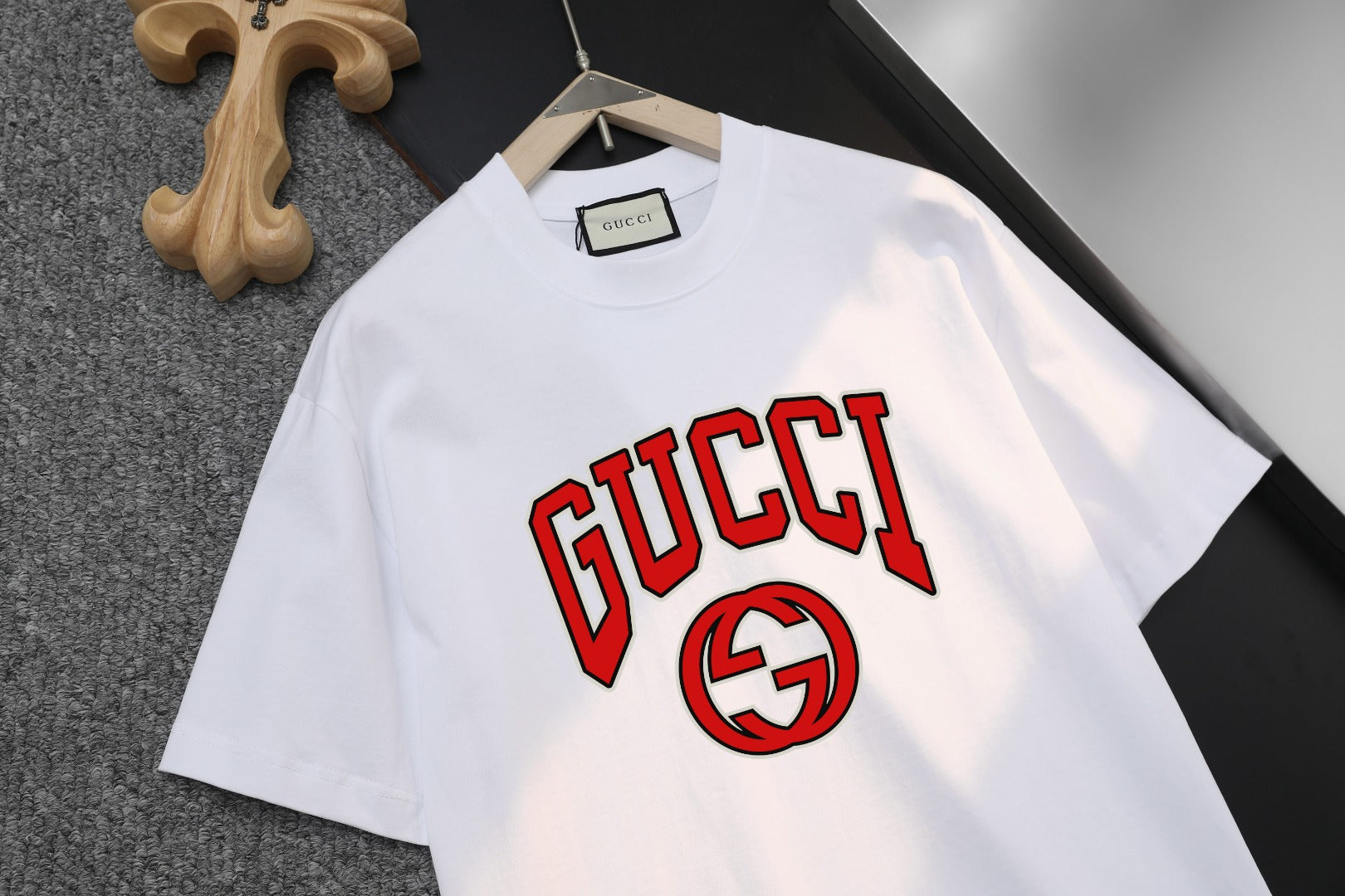 White short-sleeve T-shirt with large GUCCI text and red-and-black GG logo