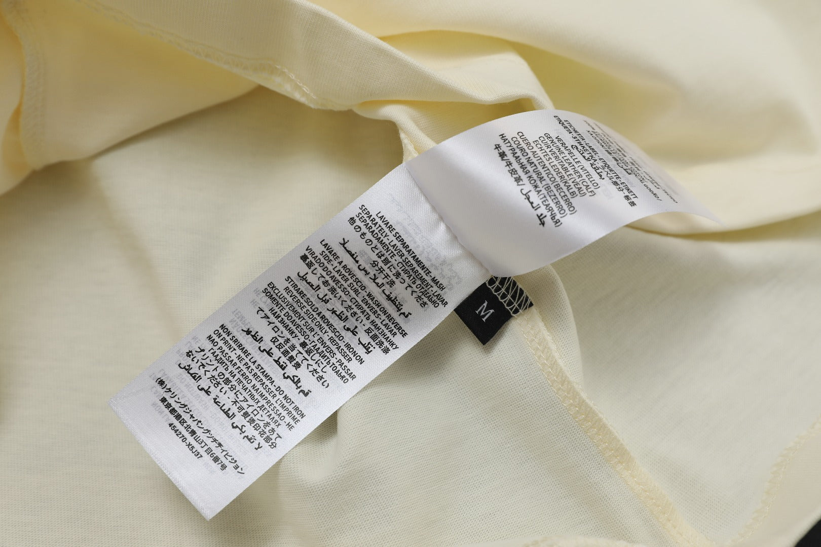 Cream Gucci T-shirt care label and size tag inside neckline.