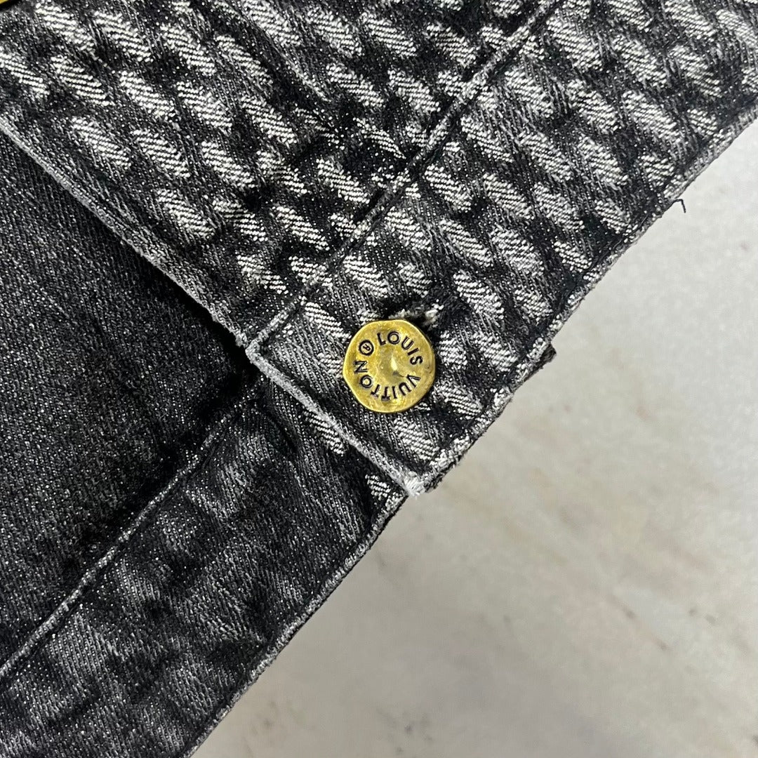 Louis Vuitton denim hem close-up with circular gold logo button