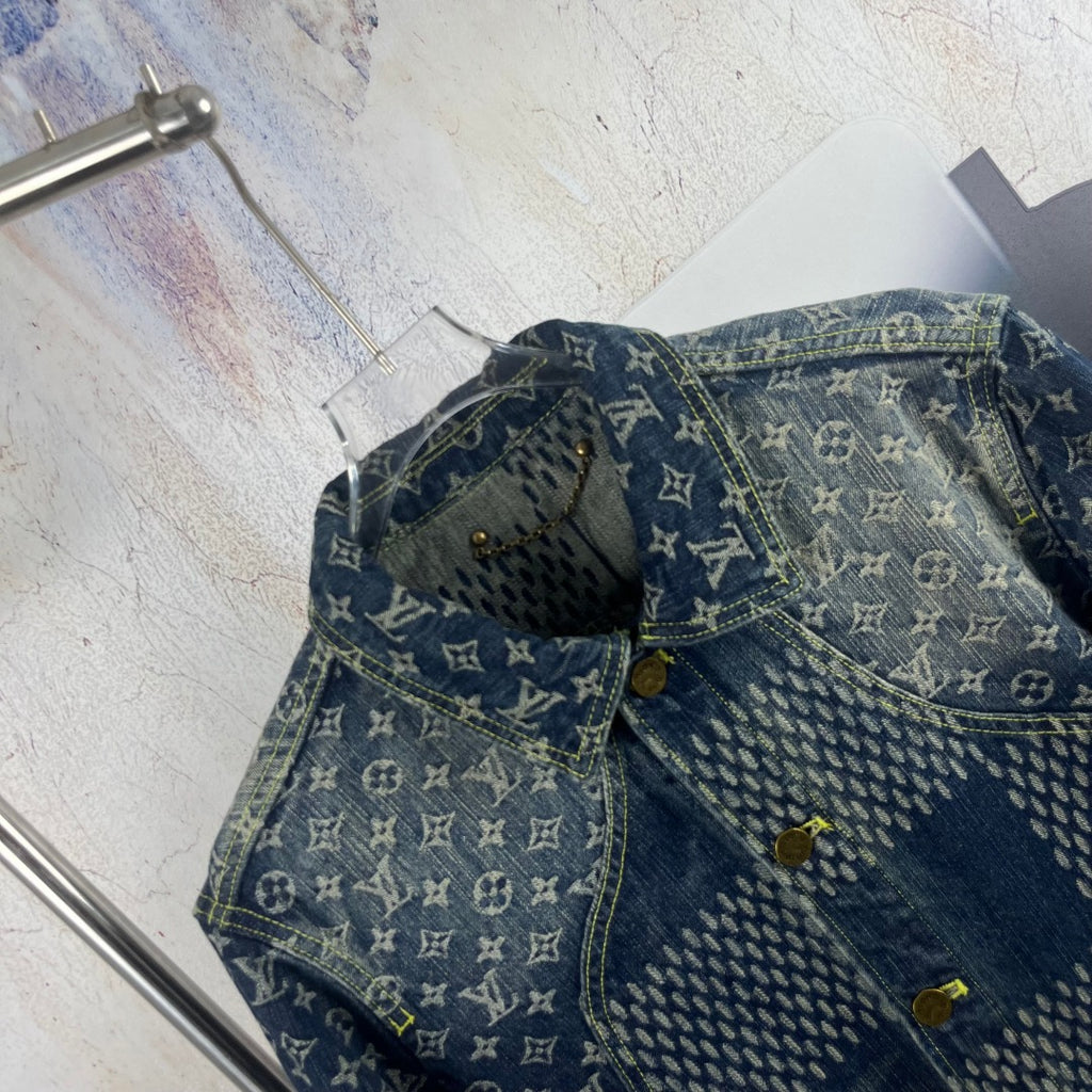 Monogram denim jacket detail with curved yoke seam and gold-tone buttons