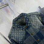 Monogram denim jacket detail with curved yoke seam and gold-tone buttons