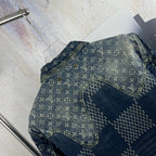 Monogram denim jacket shoulder and sleeve seam detail with curved pocket panel