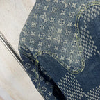Monogram denim jacket sleeve close-up with blue patchwork trim stitching