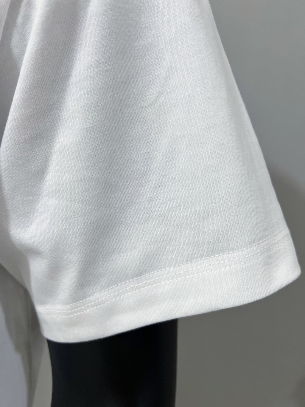 Gucci white T-shirt sleeve hem with visible stitching and curved cut