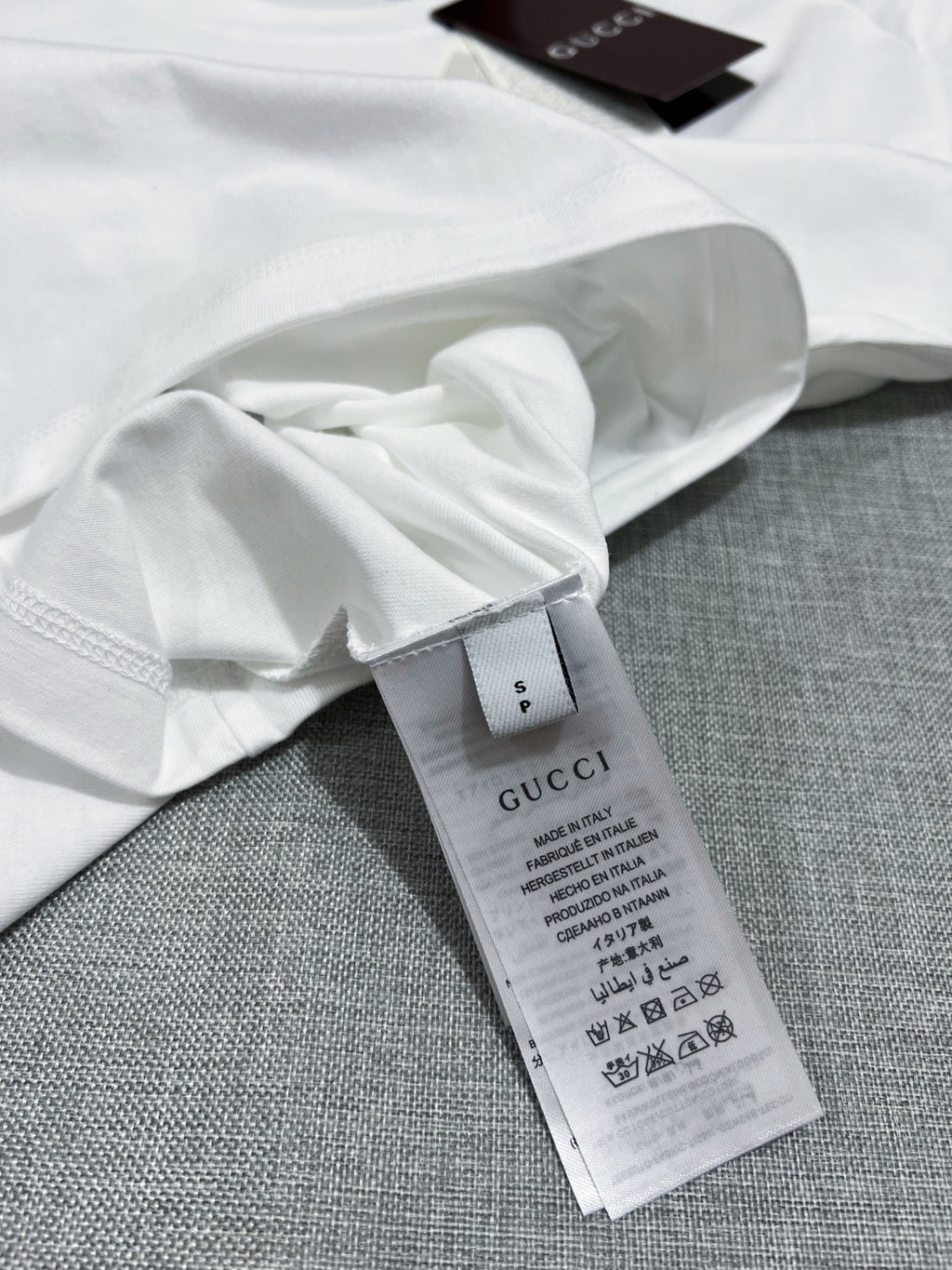 Gucci white T-shirt fabric label and care tag on inside seam