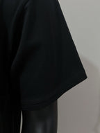 Black T-shirt short sleeve side view, hem stitching visible
