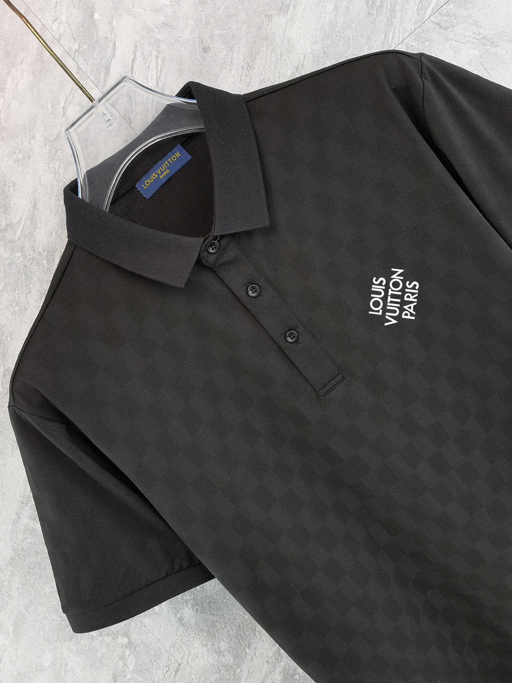 Louis Vuitton black polo shirt close-up: collared neckline, button placket, chest logo