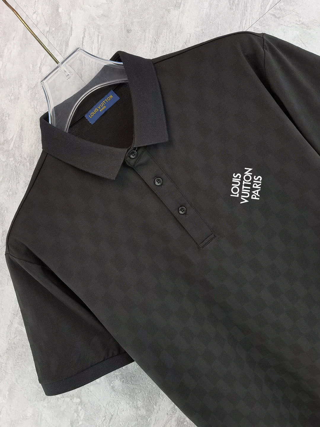 Louis Vuitton black polo shirt close-up: collared neckline, button placket, chest logo