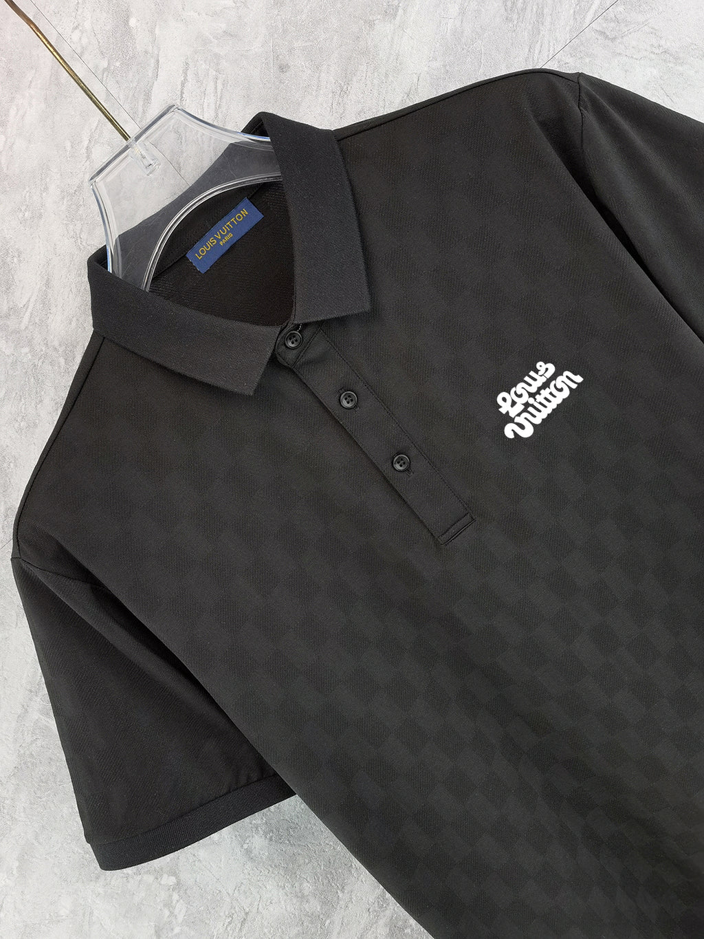 Black polo shirt front with button placket and chest logo