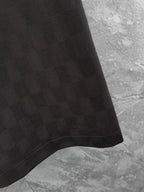 Black polo shirt hem detail with textured fabric