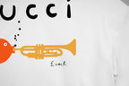 White T-shirt close-up of Gucci lettering and trumpet graphic