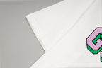 White T-shirt sleeve and side seam detail with colorful GUCCI logo edge