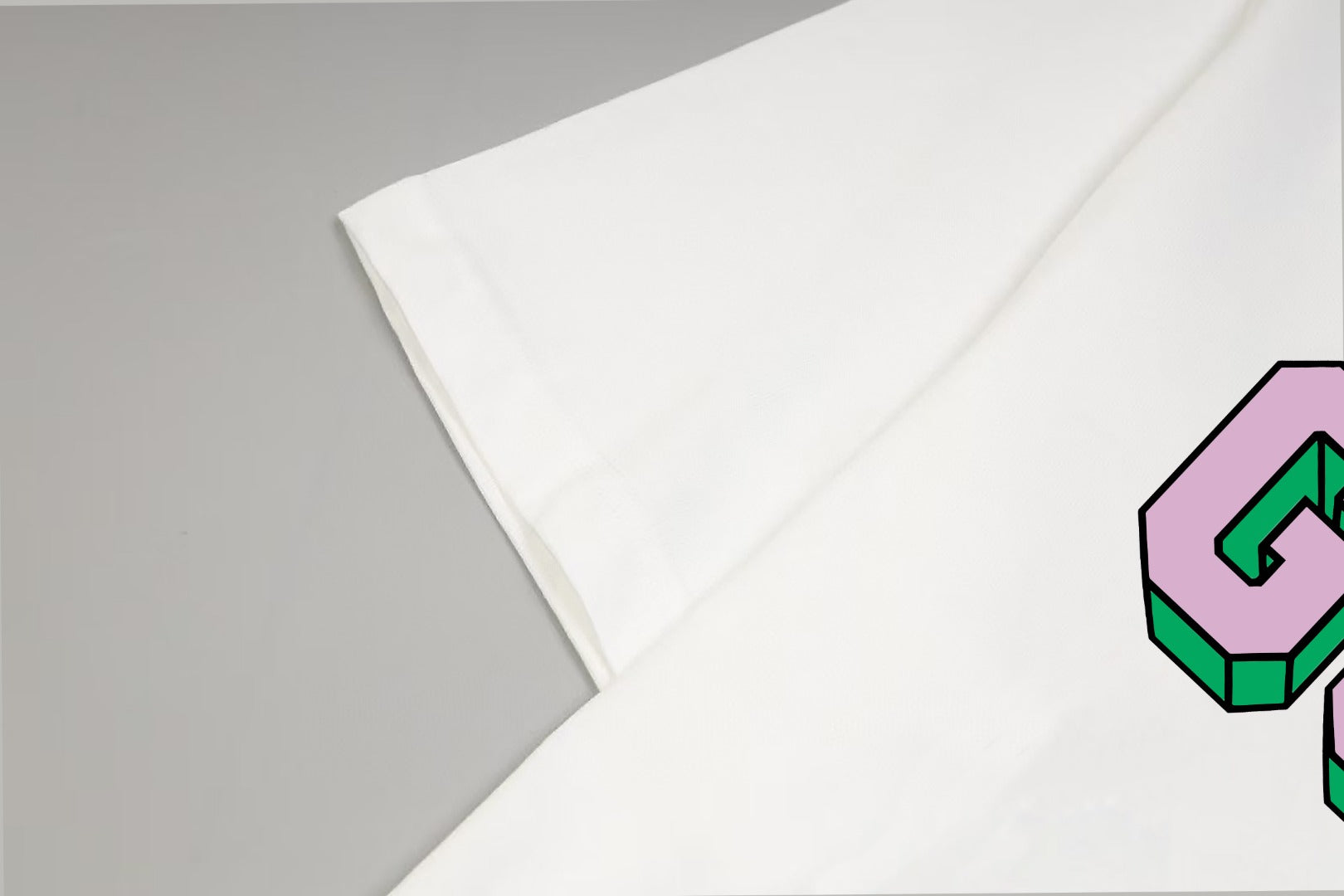 White T-shirt sleeve and side seam detail with colorful GUCCI logo edge
