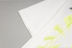 White T-shirt fabric close-up with neon yellow and green abstract print