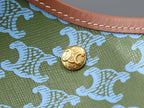 Celine logo snap clasp on green fabric with blue patterned detail