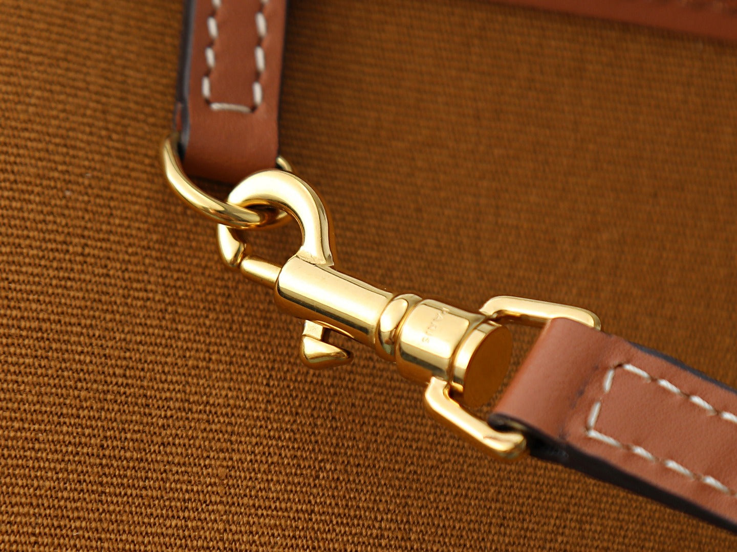 Gold tone swivel clasp on brown strap with stitched edge