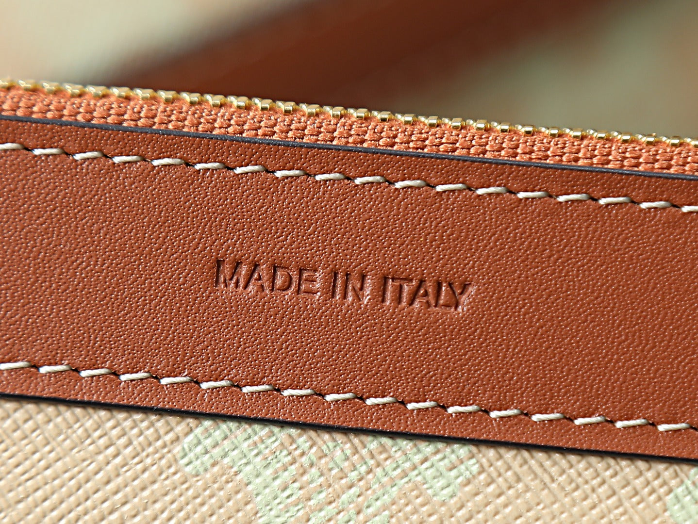 Brown leather trim with stitched edge and “MADE IN ITALY” embossing