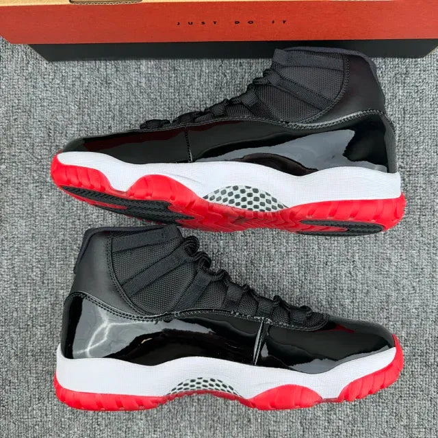 Black high-top sneakers pair view with red outsole and white cushioning midsole