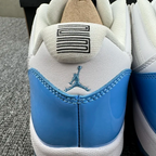 Heel close-up of white and blue low-top sneakers with Jumpman logo and tab