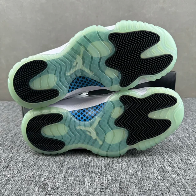 Outsole view of white sneakers showing green traction pods and black tread