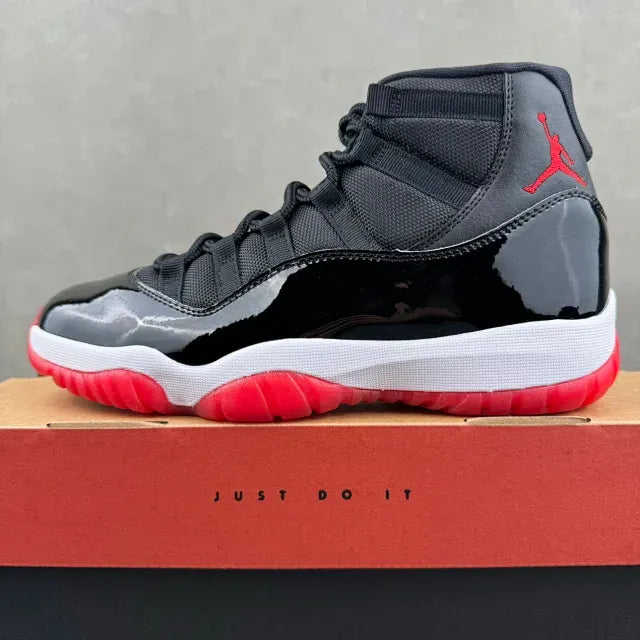 Black high-top sneaker with red Air Jordan logo, white midsole, and lace closure