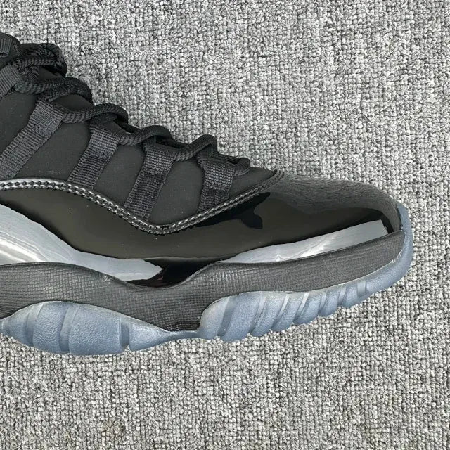 Jordan 11 high-top sneakers with black upper, gray midsole, lace-up front and side