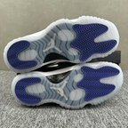 White and black low-top sneakers with blue treaded outsole, soles facing up