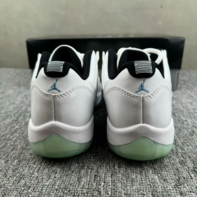 Back view of white sneakers with green heel sole and blue Jumpman logo
