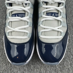 Jordan 11 sneaker toes with white laces, cream mesh quarters, navy glossy fronts