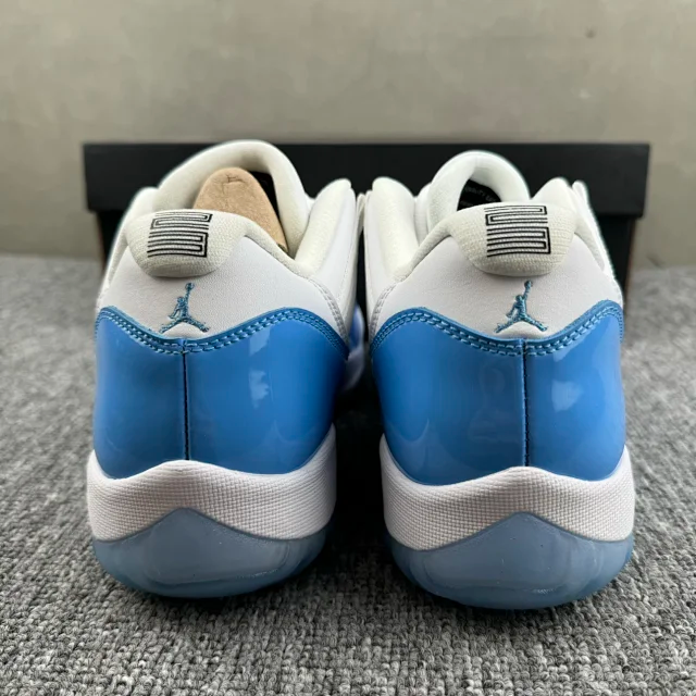 Rear view of white and blue low-top sneakers with Jumpman logo on heels