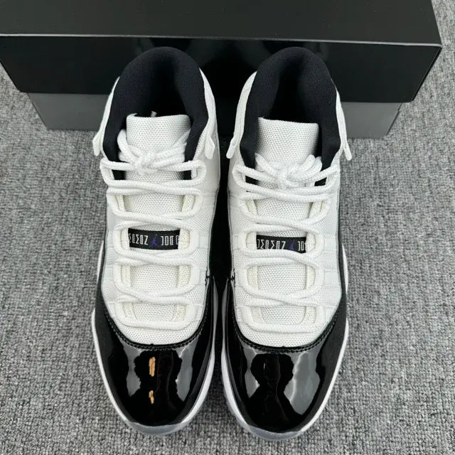 Front view of white and black sneakers with white laces and glossy black toe