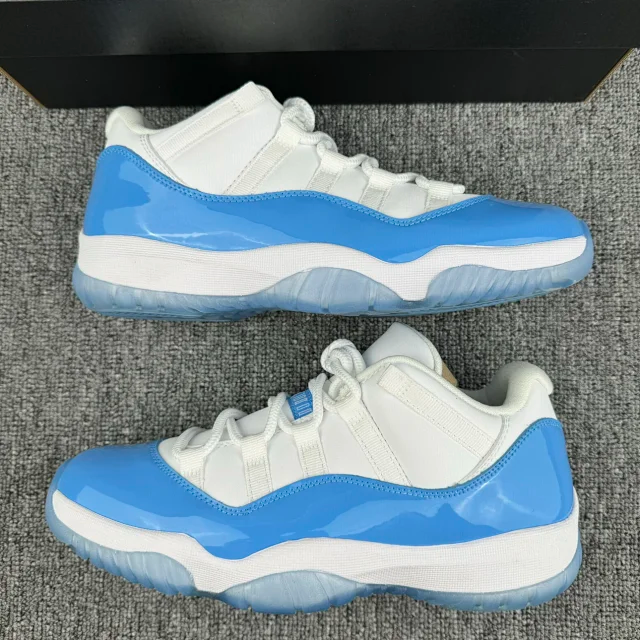 Pair of white and blue low-top sneakers on a grey surface