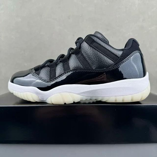 Jordan 11 lace-up sneakers with black leather-look upper, white midsole, cream outsole